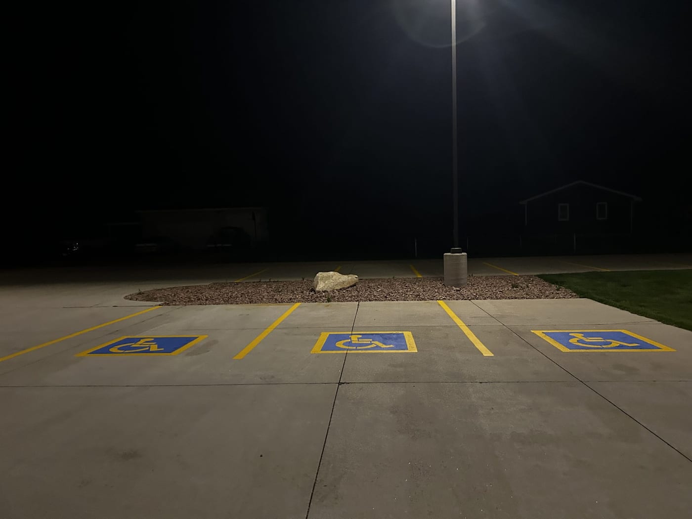 ADA stalls striped at night under a parking lot light